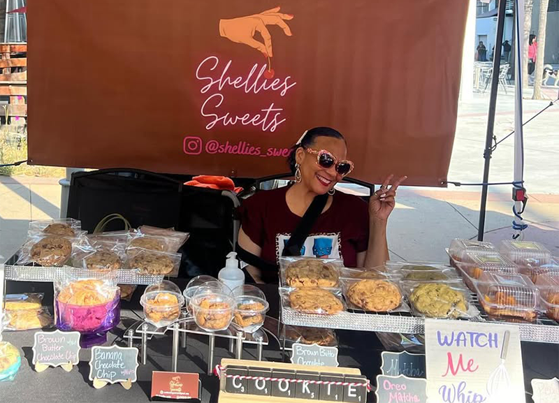 Shellie’s Sweets and Vegan Treats founder Michelle Jordan in her booth at a local farmer's market